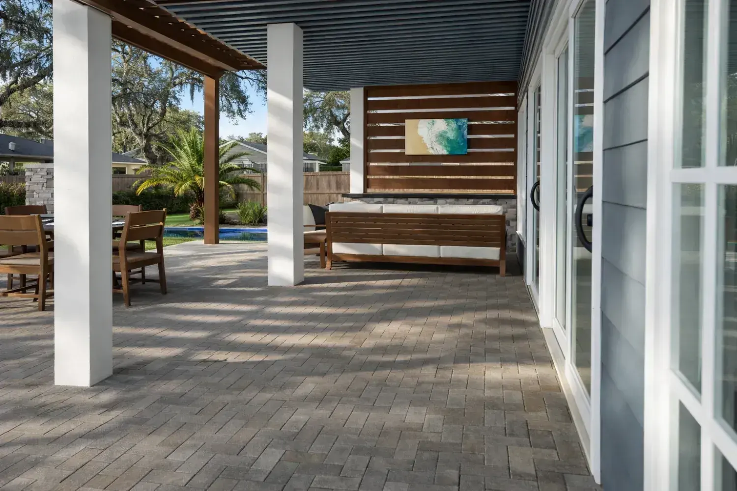 3D rendering: covered lanai with a slatted wood feature wall and TV, with the pool beyond