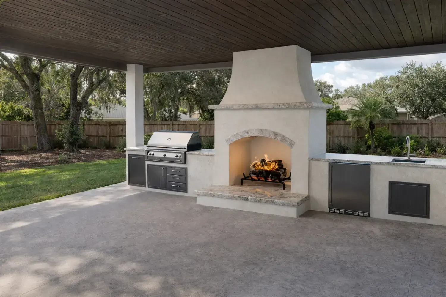 3D rendering: covered outdoor kitchen with a white stucco fireplace, built-in grill and stainless cabinets